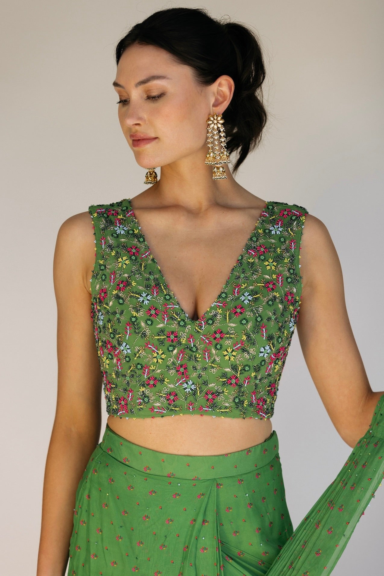 This saree has a hand-embroidered cropped top with intricate beadwork and sequins and is paired with a skirt featuring attached wraparound draping. This outfit is prestitched, so you can put it together in 30 seconds or less.