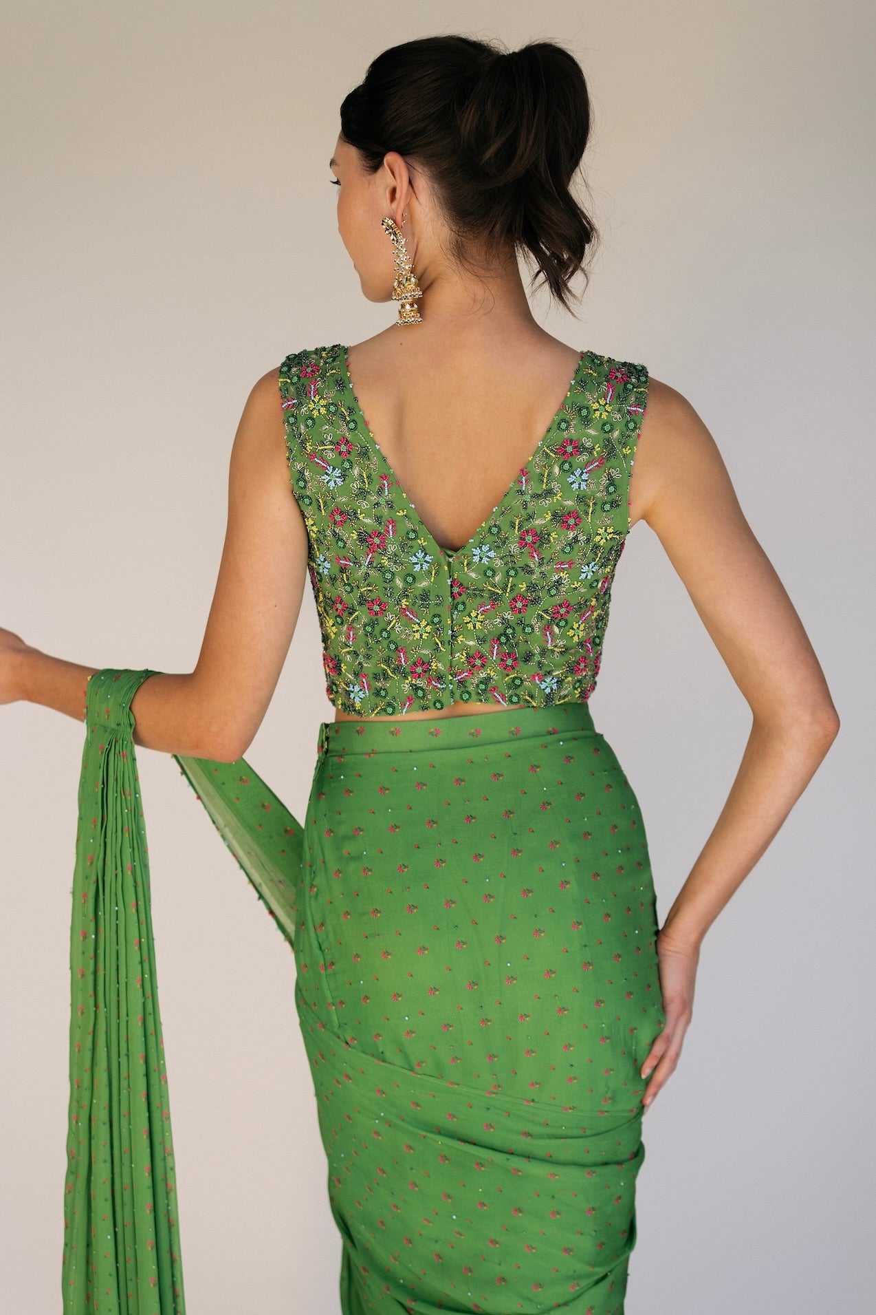 This saree has a hand-embroidered cropped top with intricate beadwork and sequins and is paired with a skirt featuring attached wraparound draping. This outfit is prestitched, so you can put it together in 30 seconds or less.