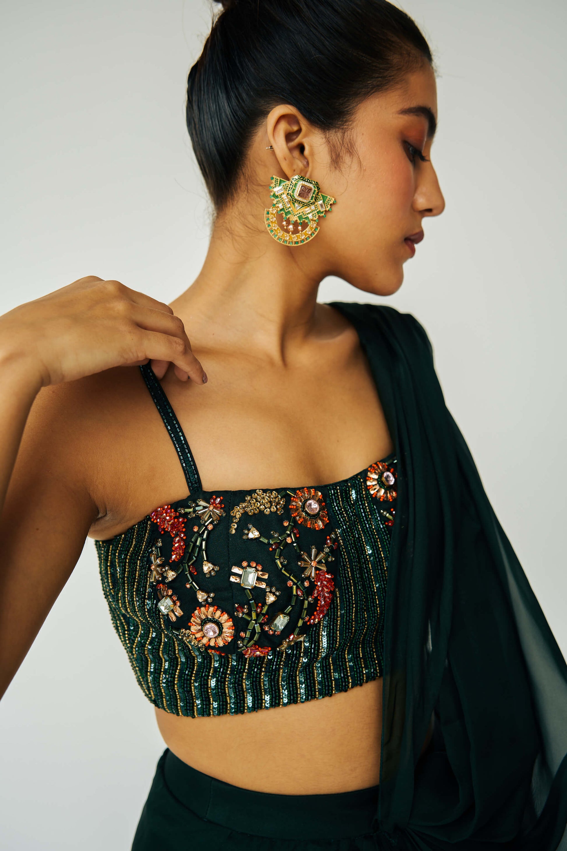 The Adya Drape Saree makes it easy to get the saree look without any pleating and features a shiny organaza skirt with an attached drape + a hand embroidered, bustier top. 