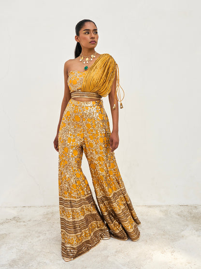 The sequined Tanvi Palazzo Set consists of a one-shoulder adjustable top and flared palazzo pants. 