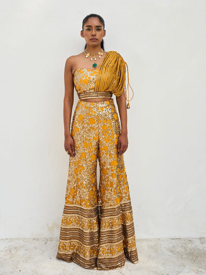 The sequined Tanvi Palazzo Set consists of a one-shoulder adjustable top and flared palazzo pants. 