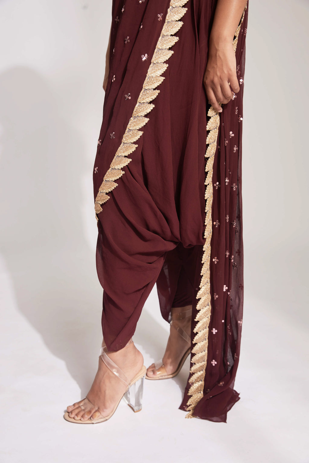 The Tara Dhoti takes the elegance of a saree's drape and combines it with the comfort of a dhoti pant. The booti-work drape is attached to the outfit and is paired with a mirror work blouse.
