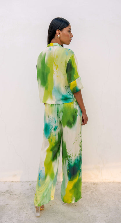 Woman in a multi-colored green printed loungewear set with clear heels. 