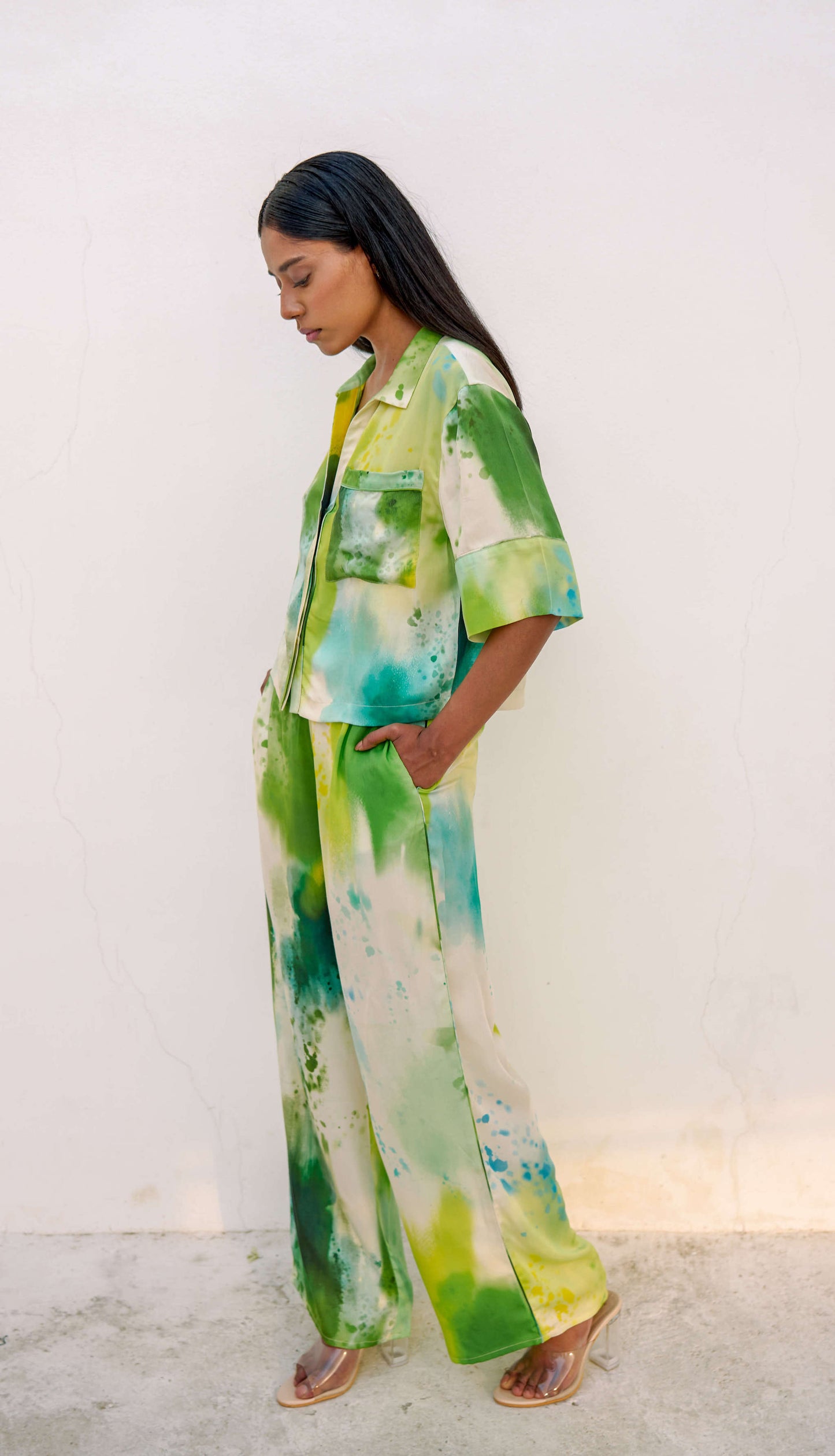 Woman in a multi-colored green printed loungewear set with clear heels. 