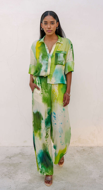 Woman in a multi-colored green printed loungewear set with clear heels. 