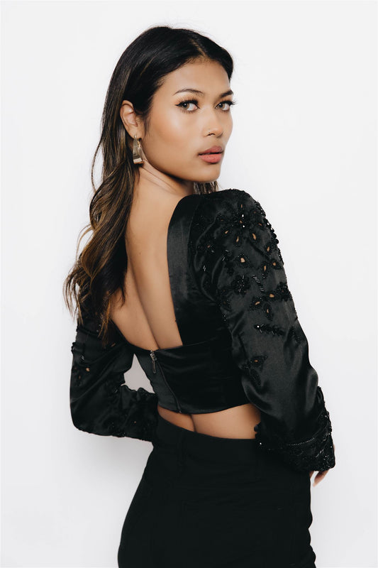 The Rani top is a long sleeve blouse with embellishment and cut work on the sleeves. Dress it up and down, this blouse is the perfect complement to a night out to your next reception. 